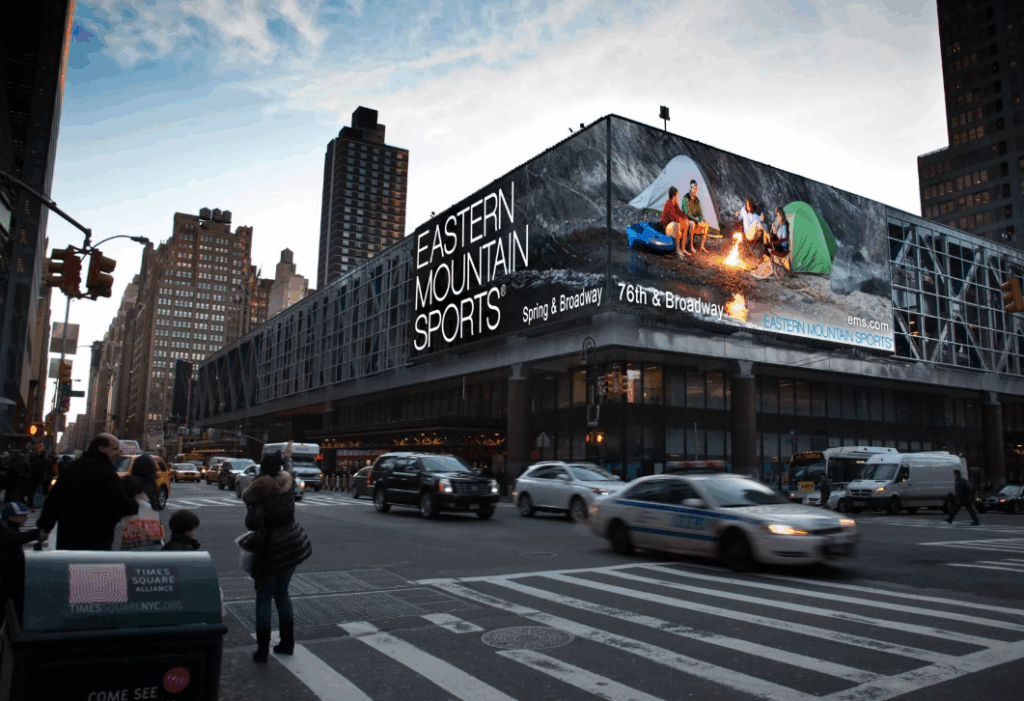 Un grand écran LED extérieur installé dans une zone commerciale moderne d'une ville.