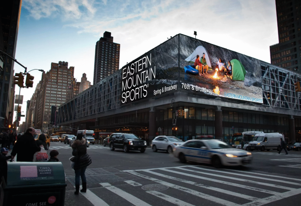 A large outdoor LED display screen installed in a modern city commercial area